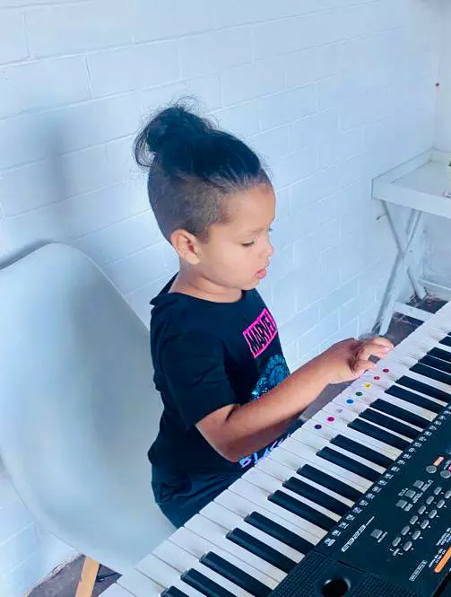 A young child playing a digital keyboard
