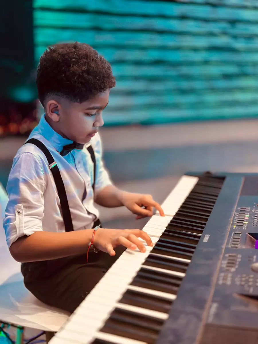 A young boy playing an electronic keyboard