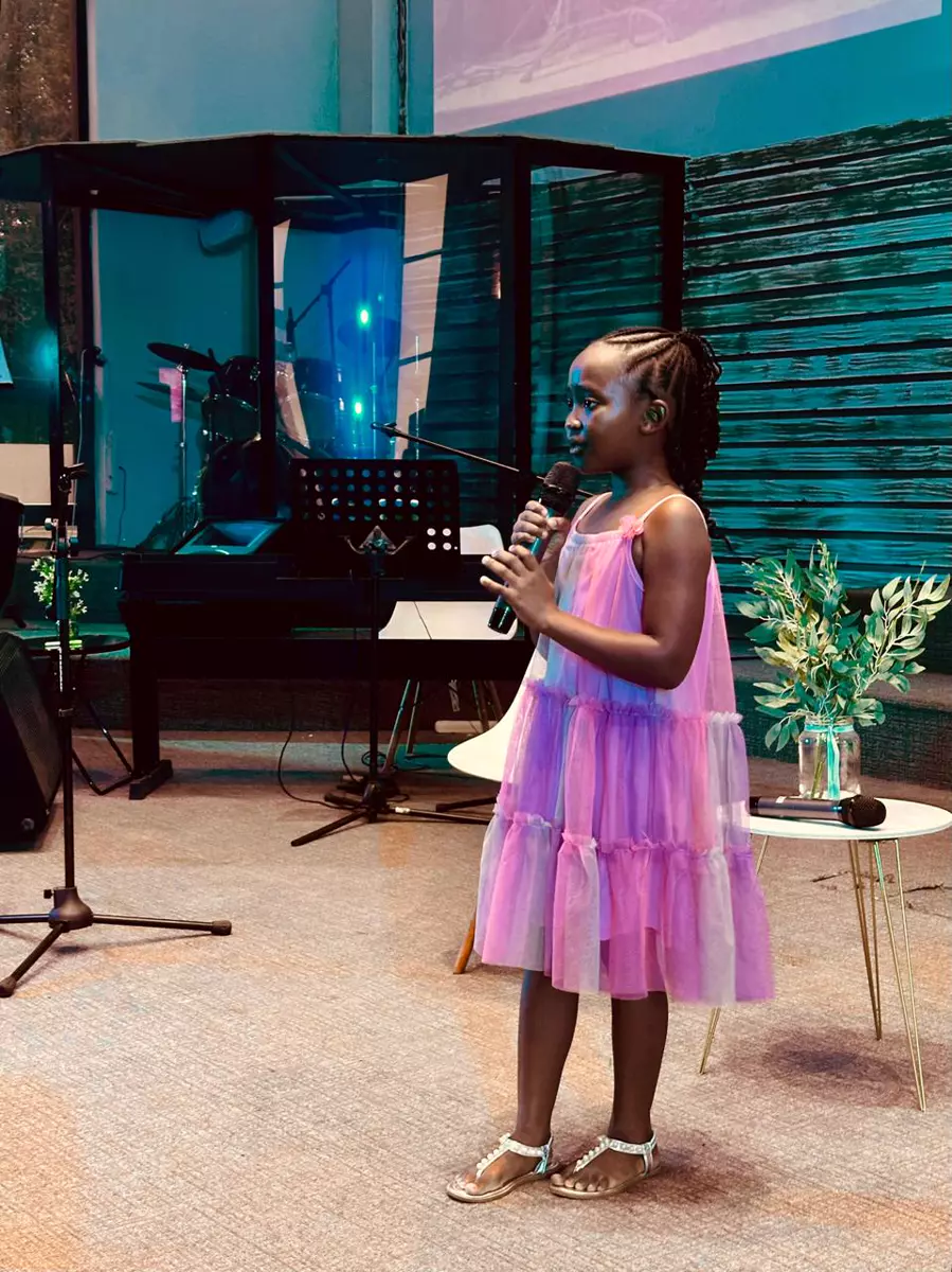 Young girl singing into a microphone on stage