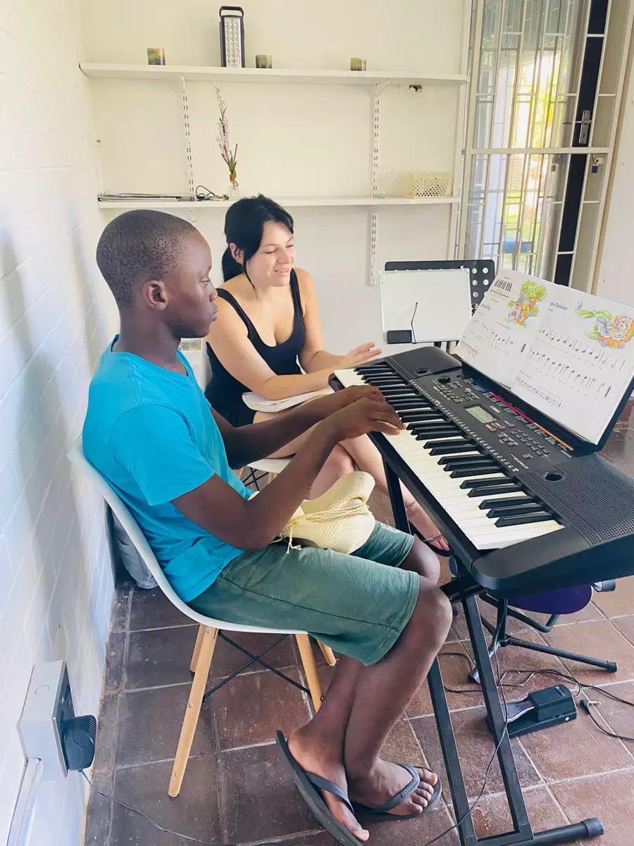 A young man playing a digital keyboard during a piano lesson