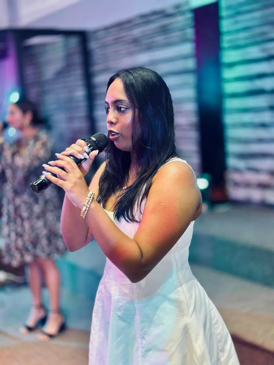 Woman singing into a microphone on stage